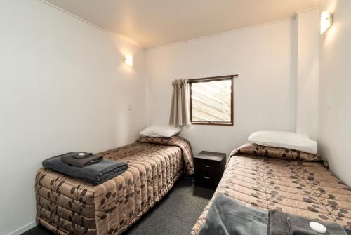 アレクサンドラにあるCentennial Court Hotelのベッド2台と窓が備わる小さな客室です。