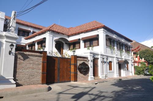 a large white house with a wooden gate at Hotel Veneto De Vigan in Vigan
