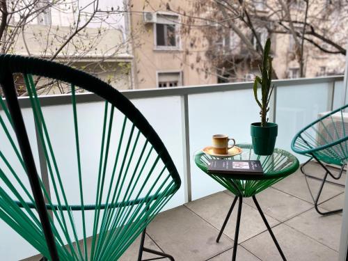 a table and chairs on a balcony with a plant at Sucre Suites in Buenos Aires