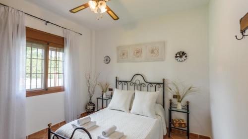 a bedroom with a bed and a ceiling fan at Casa El Lagar Alozaina by Ruralidays in Alozaina