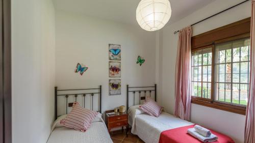 um quarto com 2 camas e uma janela em Casa El Lagar Alozaina by Ruralidays em Alozaina