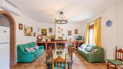 a living room with two green chairs and a table at Casa El Lagar Alozaina by Ruralidays in Alozaina