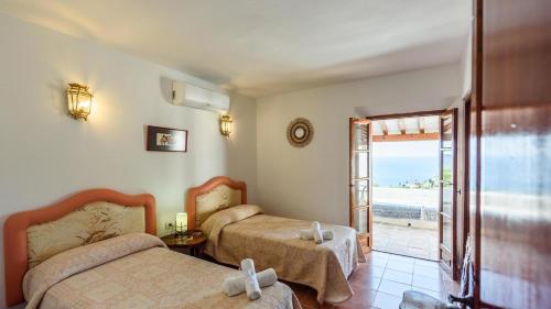 1 dormitorio con 2 camas y vistas al océano en Villa La Saliega Almunecar by Ruralidays, en Almuñécar