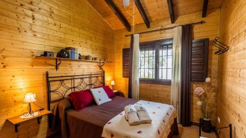 - une chambre avec un lit dans une cabane en bois dans l'établissement Casita de Madera Ardales by Ruralidays, à Ardales