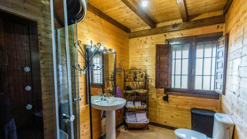 La salle de bains en bois est pourvue d'un lavabo et d'un miroir. dans l'établissement Casita de Madera Ardales by Ruralidays, à Ardales