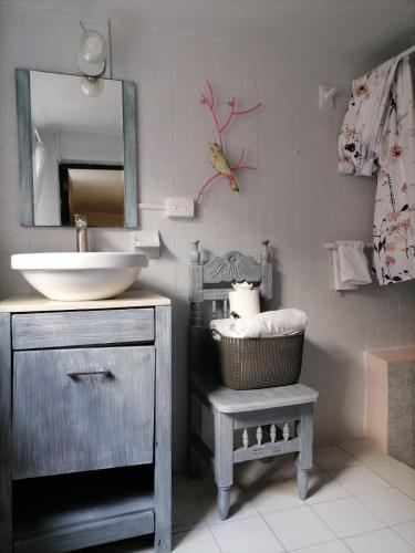 a bathroom with a sink and a mirror and a stool at Hotel Santa Ana in San Miguel de Allende