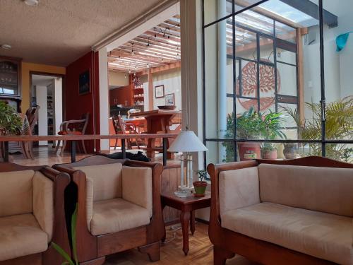 a living room with two chairs and a table at Casa de Tulia in Quito