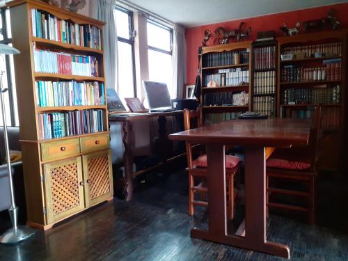 a library with a table and book shelves filled with books at Casa de Tulia in Quito