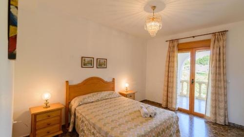 sypialnia z łóżkiem, 2 lampami i oknem w obiekcie Casa Embalse Bermejales Arenas del Rey by Ruralidays w mieście Arenas del Rey