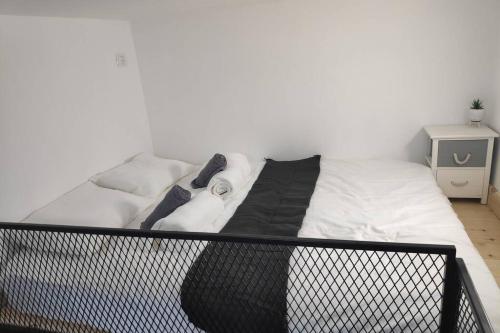 uma cama com lençóis brancos e toalhas em Centrally-located Quiet Cozy Loft apartment em Bersebá