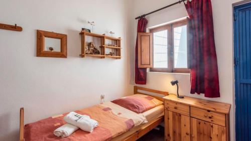 a bedroom with a bed with a wooden dresser and a window at Casa Molino los Arcos Nijar by Ruralidays in Níjar