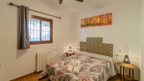 1 dormitorio con 1 cama, 2 mesas y una ventana en Casa Madrono Tolox by Ruralidays, en Tolox