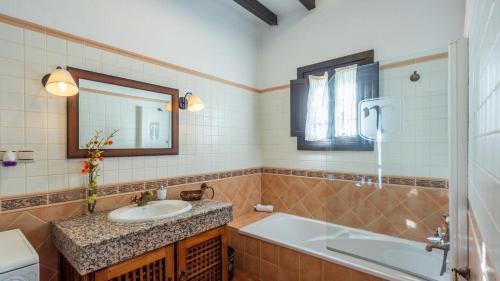 a bathroom with a sink and a tub and a mirror at Casa Castillo Malaga by Ruralidays in Málaga
