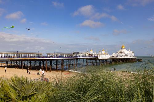 a pier with people on the beach next to the ocean at The Burlington Hotel in Eastbourne