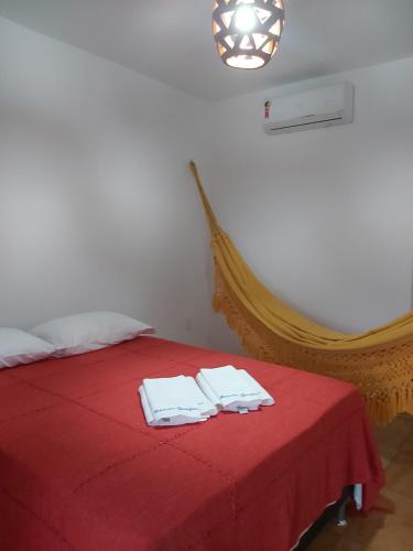 瓜吉魯的住宿－Mansão Guajiru，一间卧室配有红色的床和毛巾
