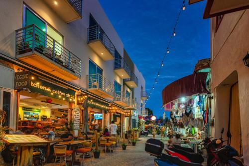 a street with tables and chairs in a city at night at Imperla Hotel in Isla Mujeres