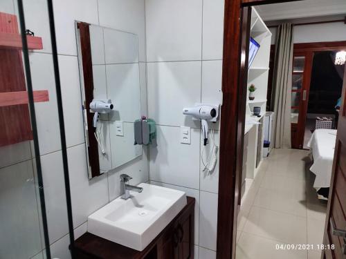 a bathroom with a sink and a mirror at Apê Casa da Flor - Maceió, Camocim-CE - Flat Pé na Areia - Vista Mar in Maceio