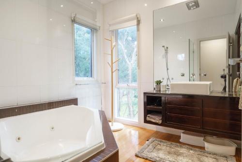 a bathroom with a large tub and a large mirror at Our Escape at Rye - Modern Beachouse in Rye