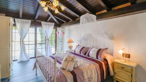 ein Schlafzimmer mit einem Bett in einem Zimmer mit Fenstern in der Unterkunft Casa Rural Malaga Spa Cartama by Ruralidays in Cártama