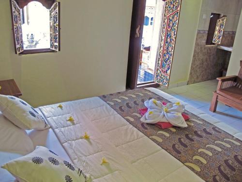 a bedroom with a bed with flowers on it at Angga Homestay in Ubud