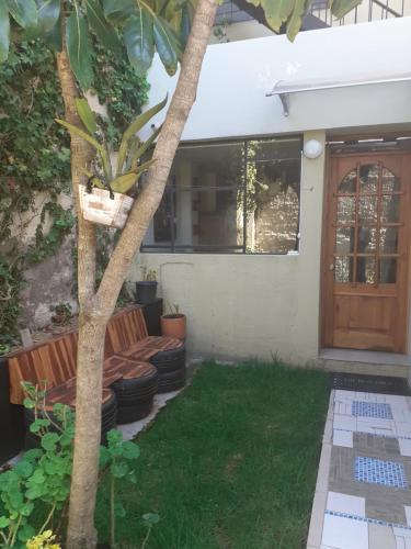 a house with a tree and a bench and a door at Casa de Tulia in Quito