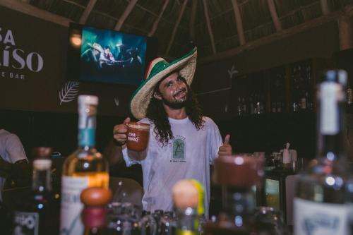 a man wearing a mexican hat holding a drink at Viajero Sayulita Hostel in Sayulita