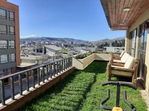 a balcony with chairs and grass on a building at Casa de Tulia in Quito