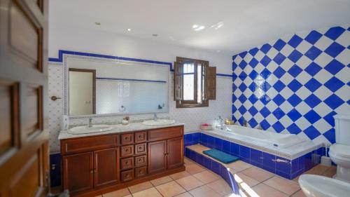 a blue and white bathroom with a tub and a sink at Cortijo Alejandro Malaga - Campanillas by Ruralidays in Málaga