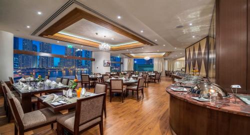 a restaurant with tables and chairs and a view of the city at City Premiere Marina Hotel Apartments in Dubai