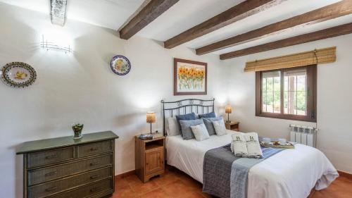 a bedroom with a bed and a dresser and a window at Cortijo del Abuelo El Gastor by Ruralidays in El Gastor