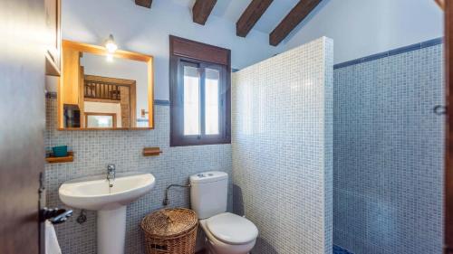 a bathroom with a sink and a toilet and a mirror at Cortijo del Abuelo El Gastor by Ruralidays in El Gastor