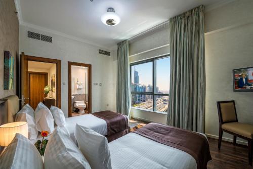 a hotel room with two beds and a window at City Premiere Marina Hotel Apartments in Dubai