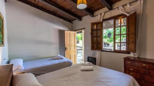 - une chambre avec 2 lits et une fenêtre dans l'établissement Cortijo El Vinculo Campillos by Ruralidays, à Malaga