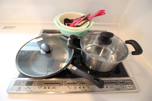 a stove with two pans and a bowl on it at Casa de nicki 恩納村 in Onna