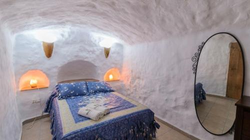 a bedroom with a bed and a mirror at Cuevas El Mirador Pozo Alcon by Ruralidays in Pozo Alcón