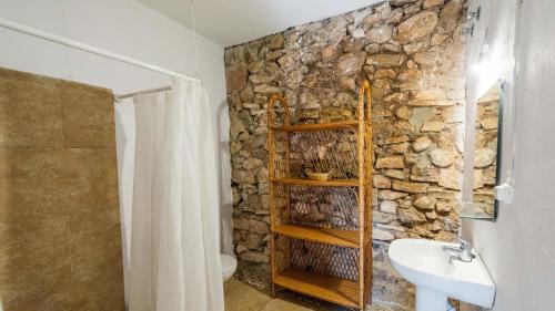 een badkamer met een stenen muur en een wastafel bij Cortijo La Vega Archidona by Ruralidays in Archidona