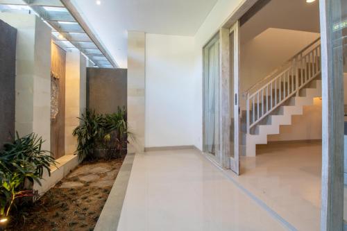 a hallway of a building with stairs and plants at Sayang Sanur Duplex in Sanur