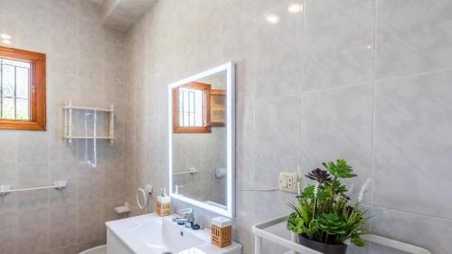 a white bathroom with a sink and a mirror at El Llano del Torcal Antequera - La Higuera by Ruralidays in Antequera