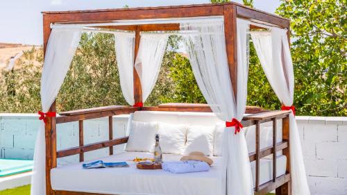 an outdoor bed with a canopy with red bows at El Llano del Torcal Antequera - La Higuera by Ruralidays in Antequera