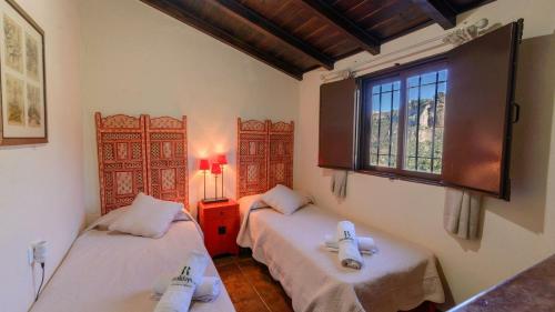 a room with two beds and a window in it at Casa El Puente Ronda by Ruralidays in Ronda