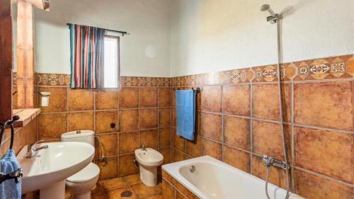a bathroom with a tub and a sink and a toilet at Villa Melendez Almachar by Ruralidays in Almáchar