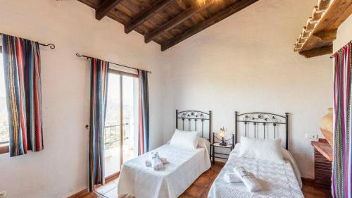 een slaapkamer met 2 bedden en een groot raam bij Villa Melendez Almachar by Ruralidays in Almáchar