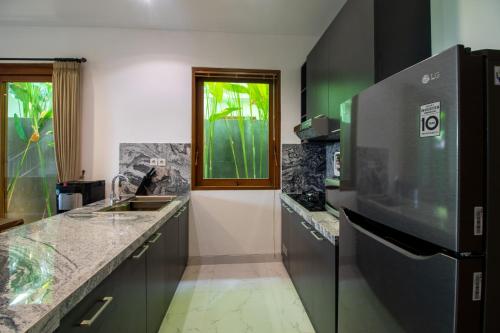 a kitchen with a sink and a counter top at Sayang Sanur Duplex in Sanur