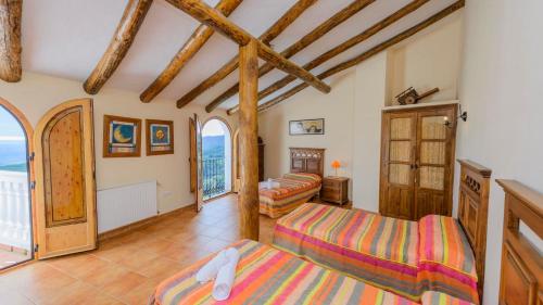 a room with two beds and a balcony at Casa El Limon Gaucin by Ruralidays in Gaucín
