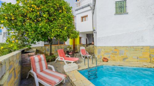 a group of chairs sitting next to a swimming pool at Casa El Limon Gaucin by Ruralidays in Gaucín