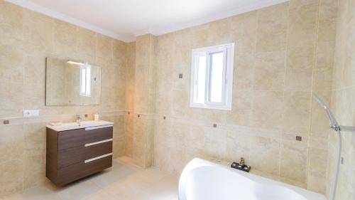 y baño con bañera, lavabo y espejo. en Villa Jazmin Vinuela by Ruralidays, en Viñuela