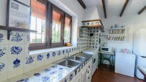 a blue and white kitchen with a sink and a window at Casa El Rosario Ronda by Ruralidays in Ronda