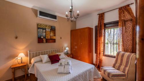 ein Schlafzimmer mit einem Bett und einem Stuhl in der Unterkunft Casa El Parque de Isabel Prado del Rey by Ruralidays in Prado del Rey