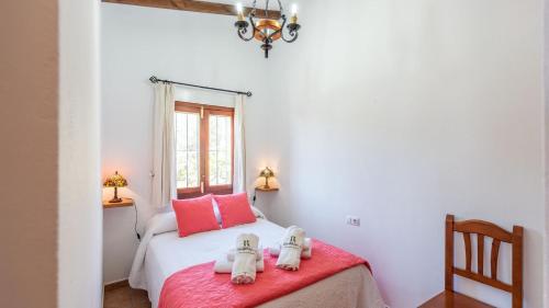 een slaapkamer met een bed met twee knuffels erop bij Casa Torre del Manzano Torrox by Ruralidays in Torrox
