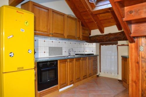 eine Küche mit einem gelben Kühlschrank und Holzschränken in der Unterkunft maison terme relax in Pré-Saint-Didier